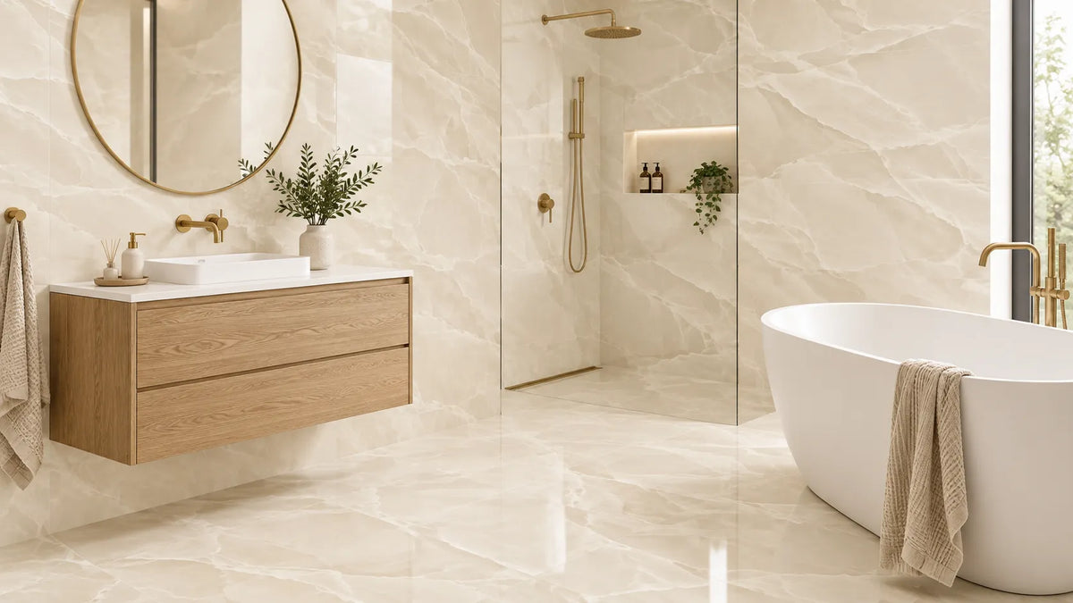 Cream large-format porcelain bathroom tiles with brushed brass taps, oak vanity and a freestanding bath