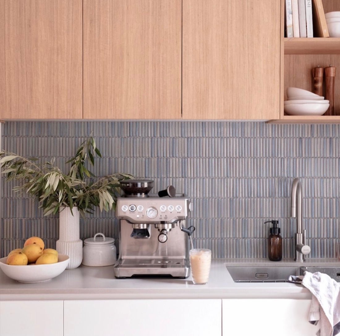 Modern kitchen interior with stylish kitchen wall tiles behind sink and coffee machine setup.