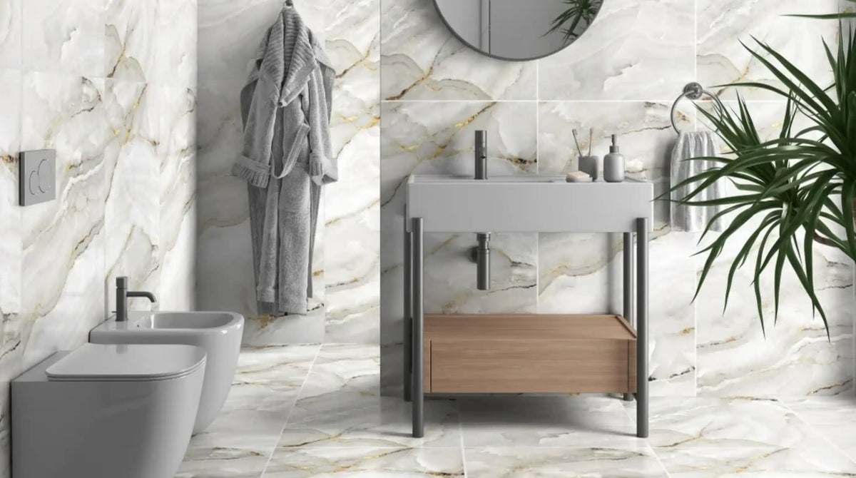 Aurora Onyx Gold glossy porcelain 60x120cm tiles installed as a full-height bathroom feature wall behind a wall-hung basin, gold veining running vertically