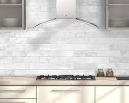 Modern kitchen with white kitchen tiles on backsplash wall, gas stove and sleek chimney hood design