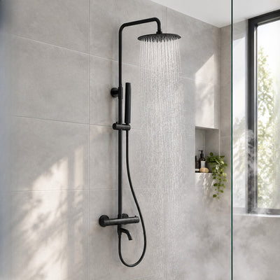 Orbis matt black exposed thermostatic bath shower mixer running in a grey-tiled walk-in shower