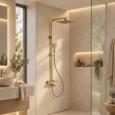 Quadra brushed gold exposed thermostatic bath shower mixer in a bright bathroom with beige stone-effect walls